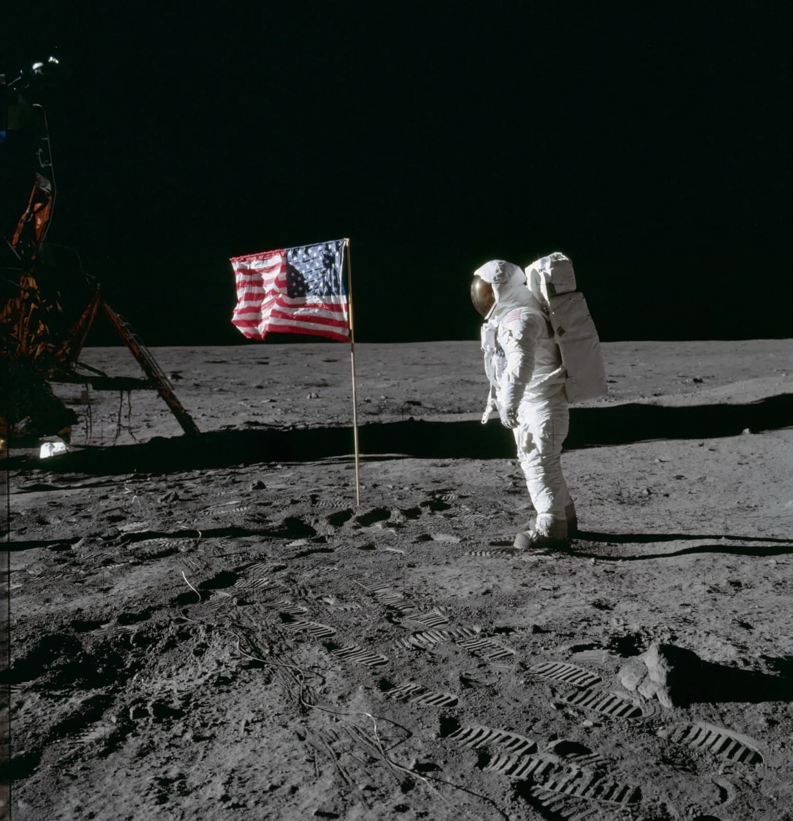 An astronaut on the lunar surface beside the flag