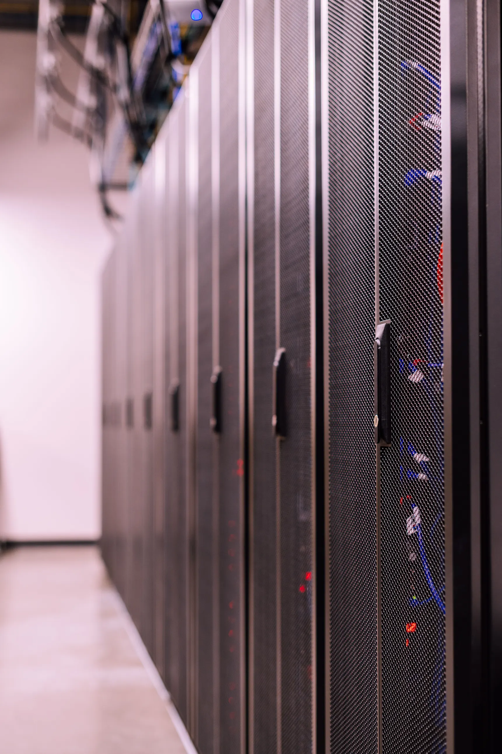A row of server racks receding down a machine room aisle